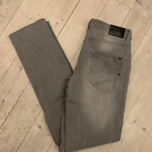 Grå jeans - Gråa slitna jeans i slimfit. Aldrig använda.