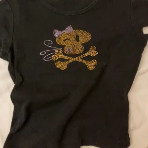 Y2k babytee - Assnygg tshirt med rhinestones! I superbra skick men lappen är bortriven, skulle uppskatta den till en S! Den är ca 38 cm lång och 34 cm bred! Pris kan diskuteras🩷