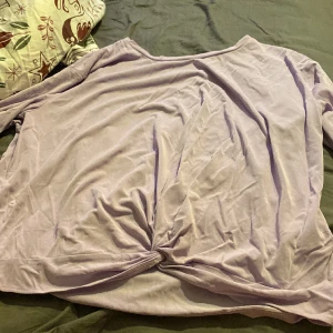Lila T-shirt med knyte. - En fin lila t-shirt med en Knut framtill. Tröjan är inte Kroppad. Skönt material.