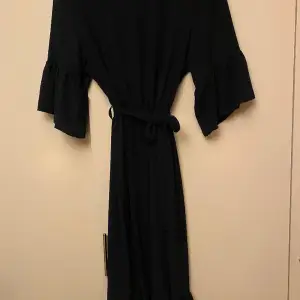 En helt underbar klänning som är mörkblå nästintill svart. V-ringad framtill och faller fint till strax under knäna. Jag är 170cm lång. 