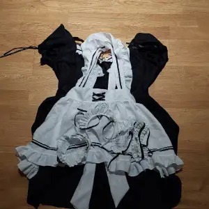 En maid dress med tillhörande accessoarer som kan användas för cosplay. Strl XS-S