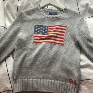 Polo raplh lauren - Jätte fin trendig polo tjocktröja med flagga på, jag är 162 och 14 år och den sitter Ferfekt på mig, säljer för att jag inte använder den. Jätte fint skick och såklart äkta