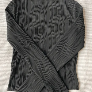 Svart jättefin långärmad - En jättefin långärmad i ett superfint mönster! Den passar perfekt till allt och formar kroppen super fint, säljer då den blivit förliten!