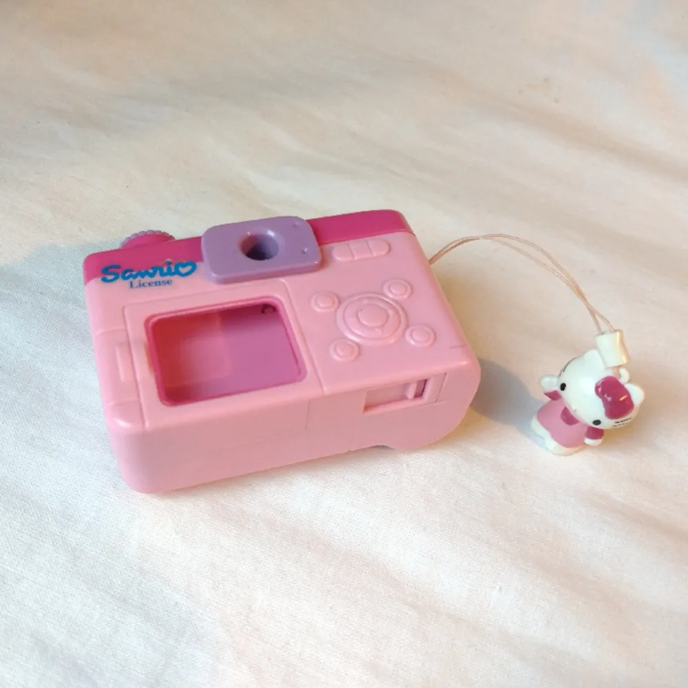 Leksakskamera med Hello Kitty. Trycker man på knappen så kommer nya bilder på henne upp i titthålet (bild 3). Finns även en lucka under så man kan lägga i smågrejer ☺️ FINNS KVAR. Övrigt.