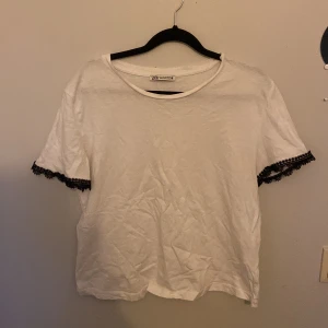Zara T-shirt  - En Sara T-shirt i vit med svart spets på kanterna i storlek M andvänt Max 3 gånger lite skrynklig för han legat i garderoben då den inte passar säljer för 130kr💕 går att pruta💕💕