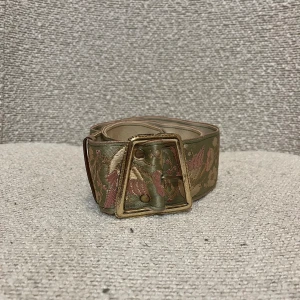 Vintage bälte - Vintage brett midjebälte i siden. Ljust grönt med fåglar och stort spänne i guld 💕 Skriv för fler bilder. Pris kan diskuteras ✉️