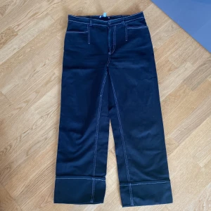 Svarta jeans  - Svarta jeans med vita sommar. Använda men i bra skick. 