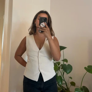 Väst i kostymmaterial  - Knappt använd kostymväst från H&M köpt för 1,5 år sen. Jättefint material och bra skick. Funkar att använda oversized eller mer tight. Färgen är vit/beige/grå. 