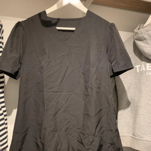 T-shirt  - En svart t-shirt som aldrig använt då den är för stor