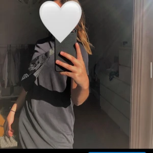 T-shirt klänning  - En svart (lite glansig) T-shirtklänning från Monika. Strl xs