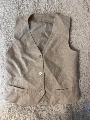 & other stories kostymväst - Säljer denna perfekta linne-västen från & other stories för den tyvärr inte passar mig längre.. Den sitter så fint på och är väldigt flattering för midjan. Den är i nyskick och har inga defekter. Storleken är 36 och passar storlek S/M.🌸🌸