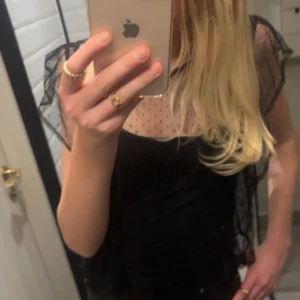 Svart Blus - Säljer denna svarta blusen, man kan ha ett svart linne under som jag har på bilden. Ny skick då den bara är använd 2 gånger.
