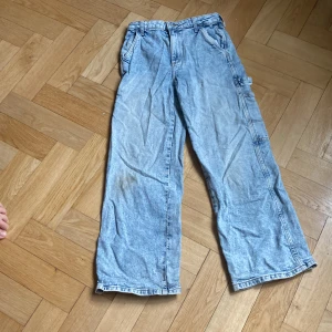 Visa jeans  - Det är ett par vid jeans från H&M med många fickor på sidorna. Den har storleken 146. 