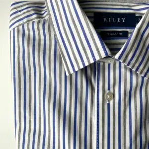 Ordinarie pris: 799 kr Skick: oanvänd   Randig skjorta från Riley Brothers  Regular fit Pointed krage Enkel manchett  100% bomull   Tvättråd: 40 grader Strykning: medel värme 