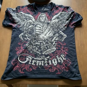 armfight t-shirt  - Riktigt fet affliction type tröja. När man ser den i verkligheten kan man se massa guld detaljer i färg som är riktigt fett