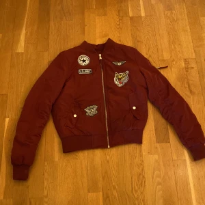 Oanvänd bomberjacka - Oanvänd och cool bomberjacka i storlek XS.  Vinröd och inköpt 2019. 