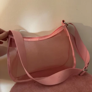 Rosa genomskinlig väska - Rosa genomskinlig väska. Knappt använd så jättebra skick. Justerbar axelrem. 