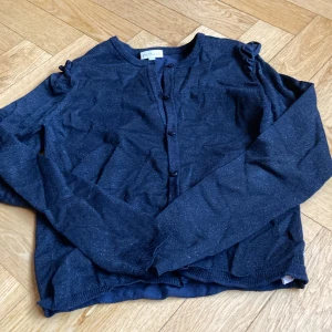 Söt kofta - Det är en mörkblå glittrig kofta från Pomp de Lux, den är i storlek 146-152