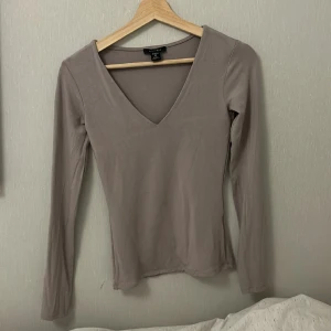 V formad långärmad - Använd en gång. Materialet är så himla skönt och så himla skön att ha på sig när det är både varmt och kallt ute. Färgen är beige men lite mörkare typ, går nästan inte att beskriva men man ser ganska exakt vilken färg det är på bilderna.