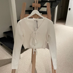 Vit kofta - Säljer min vita supergoa kofta med tre knyten ifram!! Aldrig använt den mer än att ha provat den några gånger, därför prislapp är kvar…säljer den då den är alldeles för stor tyvärr… Materialet är superskönt!!🤩🤩