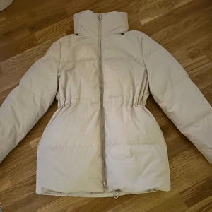 COS - Jacka ifrån COS i superfint skick.  Har lite smink i kragen (se bild) men det är inget som inte försvinner vid tvätt. Jackan har även en inbyggd luva i kragen.