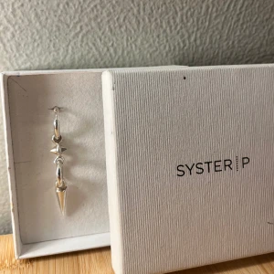 Örhänge från syster P - Säljer mitt örhänge från syster P då jag inte använder de längre, det är fin och försiktigt använt och inte använd så mycket alls🩷 ny pris 1200!! priset kan diskuteras!