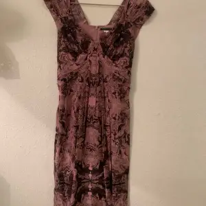 Party or cocktail dress, pure silk, fitted at waist, draping at front. Brand Peruvian Connection. New. Never worn. Lined. Dusty pink with deep grey motif. 