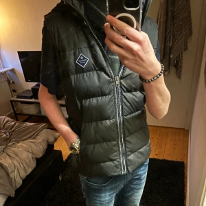 Väst  - Säljer min väst från gant. Finns lite skador på insidan av jackan men inga på utsidan. Västen är i storlek s men passar m/s. 