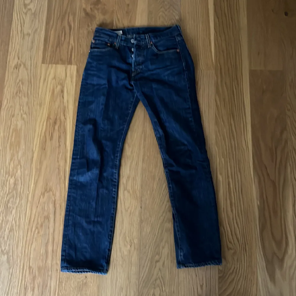 Mörkblåa Levis jenans, 501 W28 L32 killmodel. Använt fåtal gånger, har en liten tråd om gått upp som man kan se på sista bilden (högerben).. Jeans & Byxor.