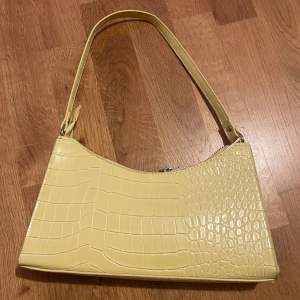 Pastell gul handväska med krokodil mönster från bikbok, aldrig använd så nyskick