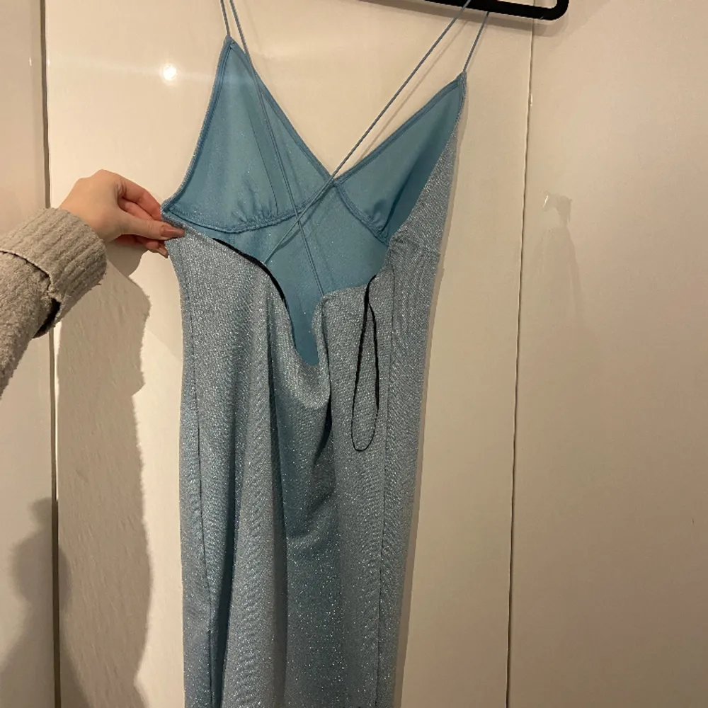 Superfin blåglittig klänning i storlek M.. Klänningar.