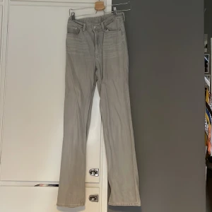Snygga gråa jenas  - Högmidjade jeans från weekday Litet hål vid ankeln av byxan på baksidan. 