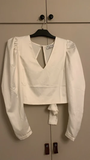 Fest Blus - Helt ny blus i stl s, med öppen rygg o knyte , glansig vit