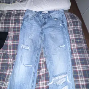 Ett par fina stradivarius jeans med hål på båda benen. Jeansen är i storlek 42 och använda några få gånger. Nytt skick✨