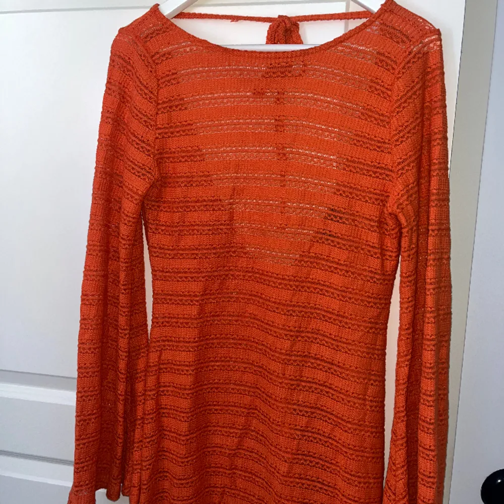 En orange virkad klänning med öppen rygg och vida ärmar, medföljer en separat underklänning. Endast använd en gång💕. Klänningar.