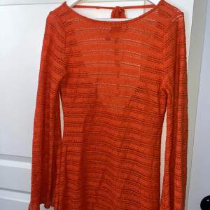 En orange virkad klänning med öppen rygg och vida ärmar, medföljer en separat underklänning. Endast använd en gång💕