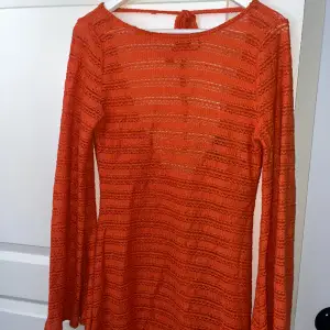 En orange virkad klänning med öppen rygg och vida ärmar, medföljer en separat underklänning. Endast använd en gång💕