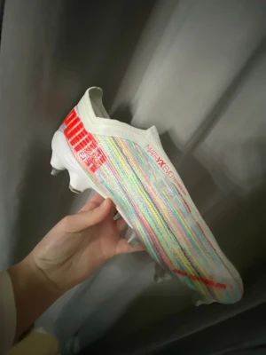 Puma Ultra fotbollsskor färgglada - STORLEK 40‼️‼️METALL DOBBAR‼️Säljer ett par Puma Ultra fotbollsskor med färgglad ovandel i vitt, rött, blått och gult. Skorna har låg vikt, strumpliknande passform och mönstrad textil för extra grepp. Perfekta för snabba spelare. Vann dessa sköna skor på 3Arena i en lottning med Hammarbys dam A-lags lagkapten Alice Carlsson‼️ HELT NYA! OANVÄNDA‼️‼️