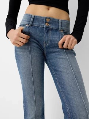 Blå bootcut jeans med pressveck - Snygga blå bootcut jeans med markerade pressveck framtill och dubbla knappar i midjan. Jeansen har klassiska fickor både fram och bak samt kontrastsömmar. Materialet är denim och passformen är utsvängd nedtill för en cool look.