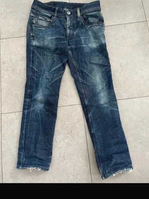 Blå raka jeans med slitningar - Säljer ett par riktigt snygga jeans med unika fades. De är straight fit och sitter riktigt bra.                                Mått 📐   Midja: 44 Ytterbenslängden: cirka 97 Benöppning: 20 cm 