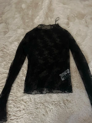 Svart mesh långärmad topp - Säljer en svart mesh topp med lång ärm. Toppen är genomskinlig och har en tight passform.