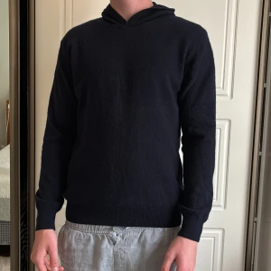  Mörkblå stickad hoodie i kashmir - Mörkblå hoodie i kashmir med enkel och clean design. Tröjan är stickad, har långa ärmar och en klassisk huva utan snörning. Från Oscar Jacobson nypris: 1599.        Storlek M men passar även S!