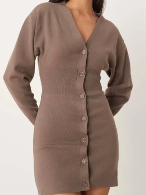 Brun stickad kortklänning med knappar - Superfin brun stickad klänning med v-ringning och långa ärmar. Klänningen har en figurnära passform och knappar hela vägen framtill. Perfekt för dig som gillar en enkel men snygg look. Prislappen sitter kvar, oanvänd.