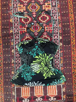 Svart halterneck topp med mönster - Snygg svart halterneck topp med färgglatt grafiskt mönster i grönt, blått och vitt. Toppen har knyt i nacken och dekorativa svarta pärlor framtill. Materialet känns stretchigt och följsamt, perfekt för en trendig look.