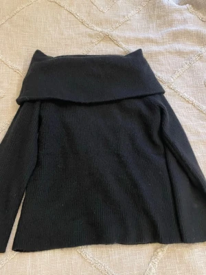 Svart off shoulder stickad tröja - Svart stickad tröja med bred off shoulder-krage och långa ärmar. Tröjan har en rak passform och är ribbstickad för en stilren look💞