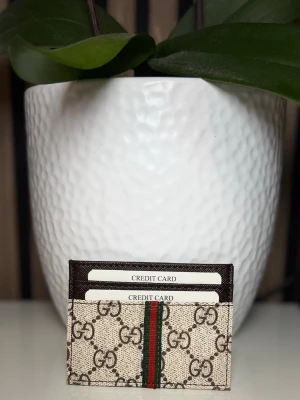  beige kortfodral  - Fodralet har plats för flera kort och detaljer i mörkbrunt läder. Perfekt accessoar för dig som gillar lyxig och tidlös design.