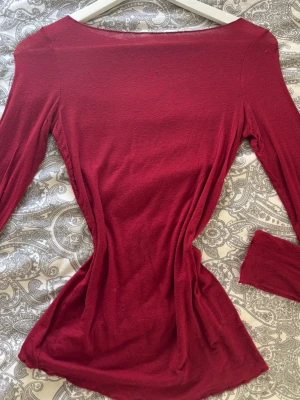 Vinröd långärmad topp från Intimissimi - Vinröd långärmad topp från Intimissimi i mjuk bomullsblandning med kashmir. Topp med enkel, figurnära passform och bred ringning. 