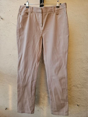 Beige raka jeans med fickor - Beiga, stretchiga jeans. Ingen lapp kvar men skulle säga storlek M-L. Fläck på framsida av vänster ben som man ser närmre på sista bilden, annars fint skick.