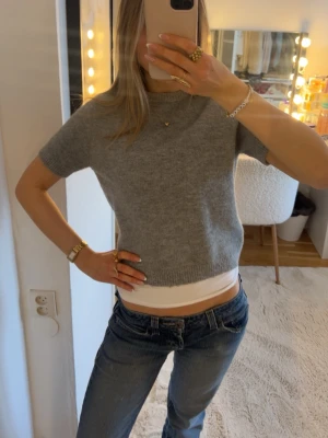 Grå stickad kortärmad tröja - Mysig grå stickad tröja med trekvarts ärmar från Zara. Tröjan har en enkel, rak passform och är perfekt att matcha med jeans eller kjol. Älskar och passar perfekt nu till våren! 💖💖