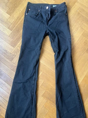 Svarta flare jeans från 157 W28 L32 - Säljer ett par svarta flare jeans från 157 i storlek W28 L32. Jeansen har klassisk femficksmodell, utsvängda ben och är tillverkade i ett mjukt jeansmaterial. Perfekta för dig som gillar en retro och trendig look.